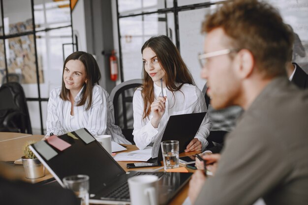 Les gens travaillent sur le projet. Homme et femme en costume assis à la table. Les hommes d'affaires utilisent un ordinateur portable.