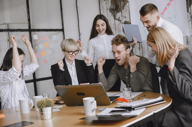 Les gens travaillent sur le projet. Hommes et femmes en costume assis à la table. Les hommes d'affaires utilisent un ordinateur portable.