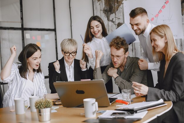 Les gens travaillent sur le projet. Hommes et femmes en costume assis à la table. Les hommes d'affaires utilisent un ordinateur portable.