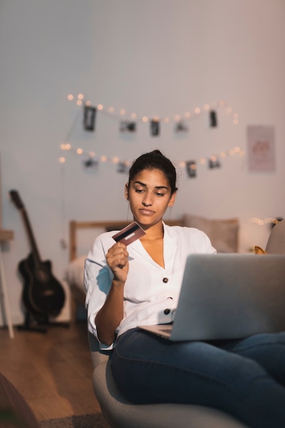 Gentil femme regardant une carte de crédit