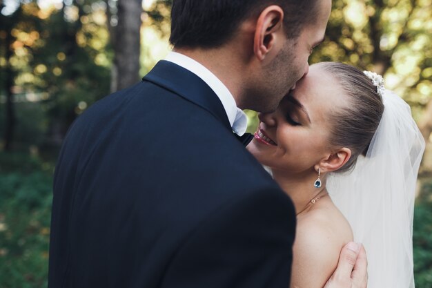 Gentle mariée et mariée embrassant dans le parc