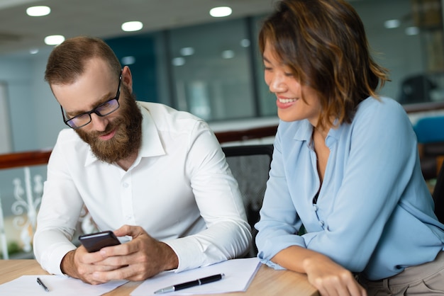 Photo gratuite gestionnaire concentré homme lisant un message sur le téléphone