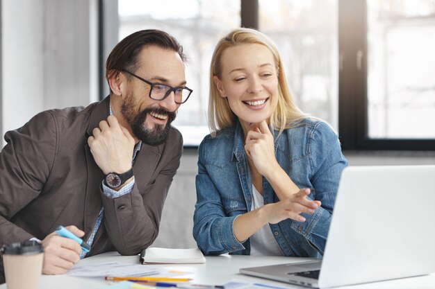 Gestionnaire de femme blonde heureuse a une conversation avec un collègue masculin