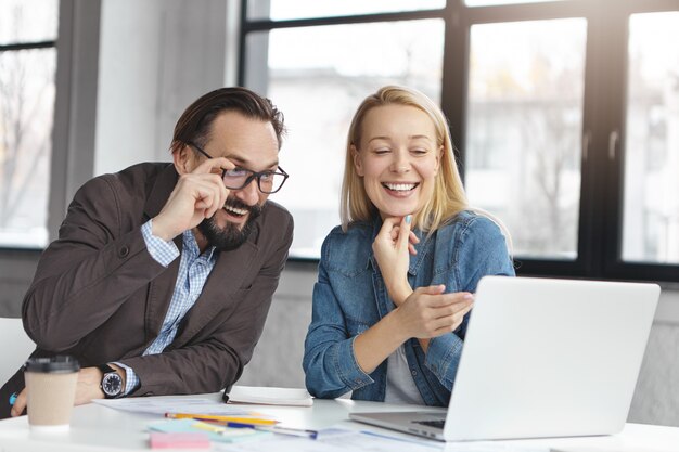 Gestionnaire de femme blonde heureuse a une conversation avec un collègue masculin