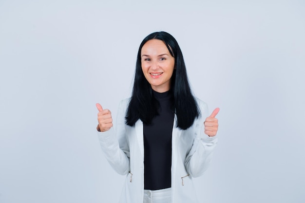 Gilr souriant regarde la caméra en montrant un geste parfait sur fond blanc