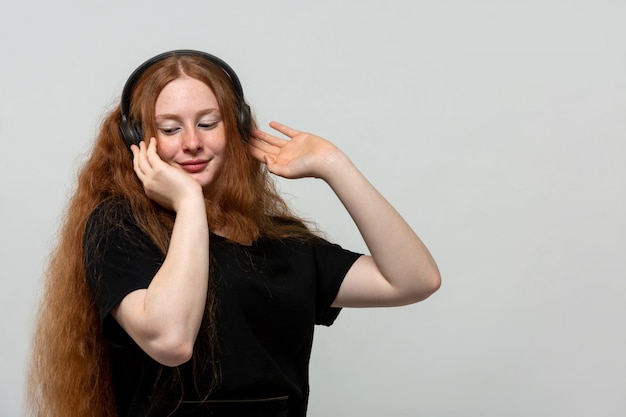 gingembre dame écouter de la musique en robe noire sur gris