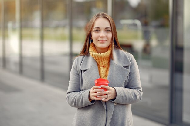 Girl, debout, grand, bâtiment, gris, manteau