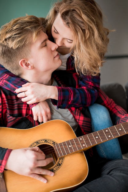 Photo gratuite girl hugging boyfriend jouer de la guitare