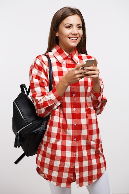 Girl in casual texting friends looking away smiling heureusement