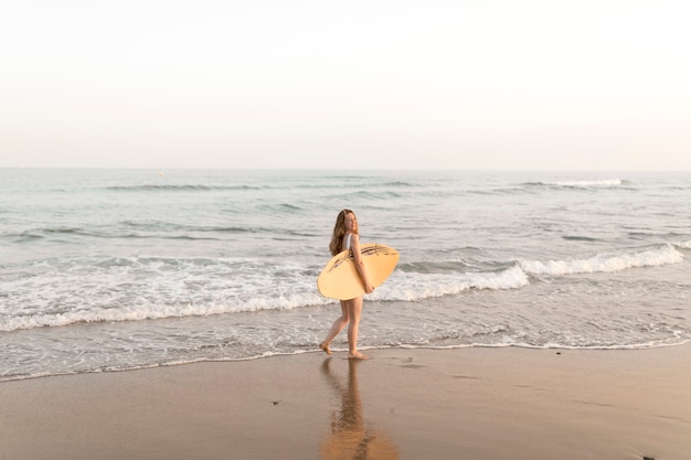 Girl, tenue, planche surf, debout, près, les, rivage
