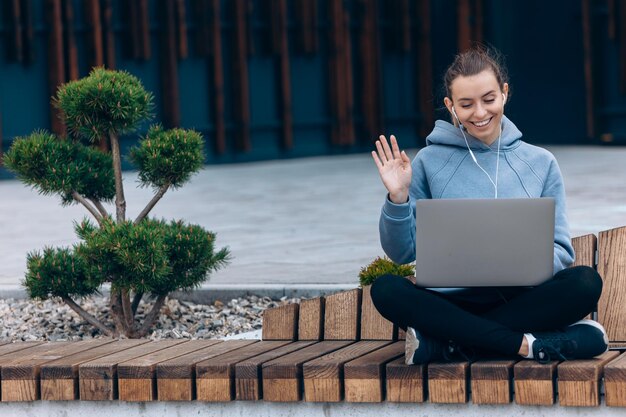 Girll avec des écouteurs faisant un appel vidéo en agitant