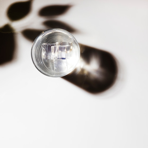 Glaçons en verre transparent avec ombre sur fond blanc