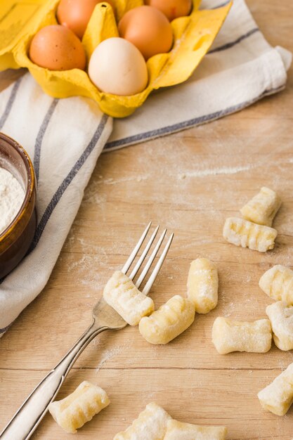 Gnocchi de pommes de terre fraîches faites maison avec une fourchette sur une table en bois