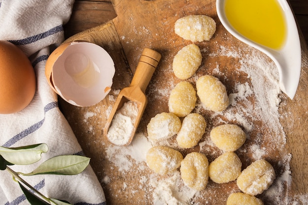 Photo gratuite gnocchi de pommes de terre non cuites à plat sur une planche à découper