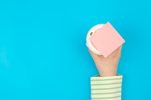 Photo gratuite gobelet en papier jetable et rappel de papier vierge dans la pose à plat de la main féminine