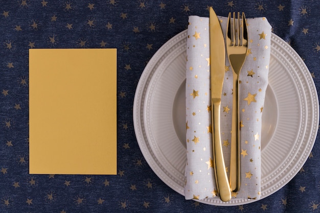 Photo gratuite gold fourchette et couteau sur assiette avec du papier