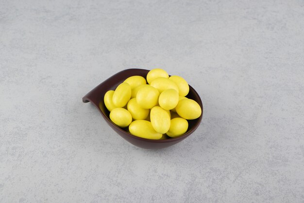Gommes jaunes dans le bol sur la surface en marbre