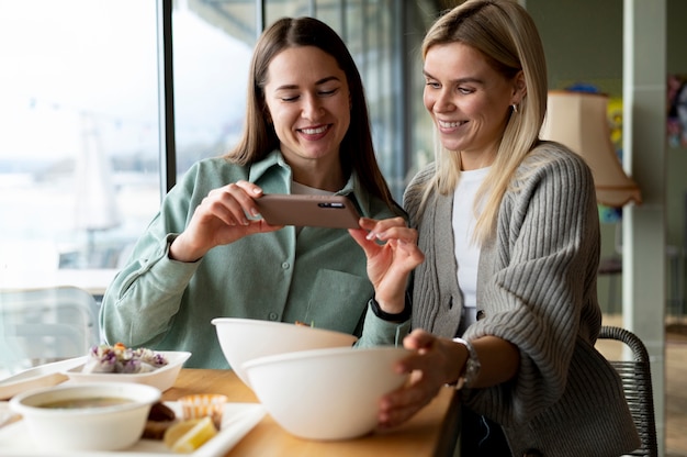 Gourmet prenant la photo de deux bols avec de la nourriture