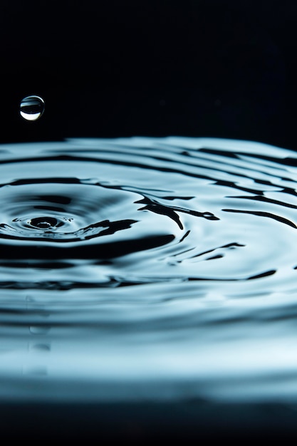 Photo gratuite goutte créant un effet d'entraînement dans le liquide