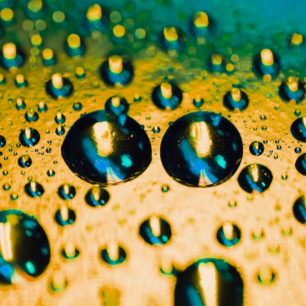 Photo gratuite goutte d'eau sur le fond de surface dorée