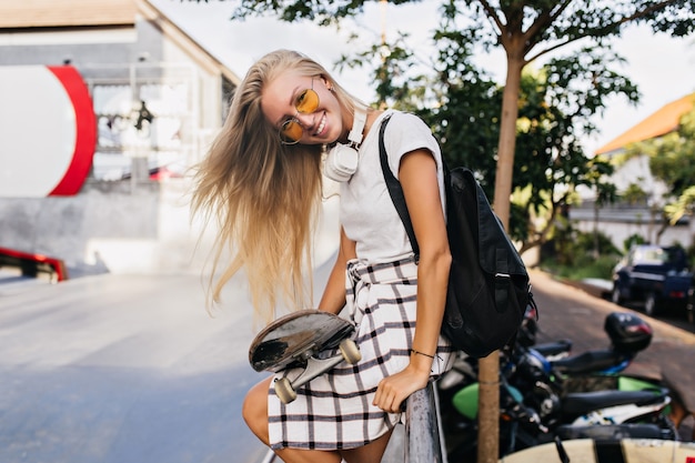 Gracieuse femme caucasienne dans les écouteurs exprimant des émotions positives sincères.