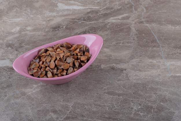 Graine délicieuse dans le bol sur la surface en marbre