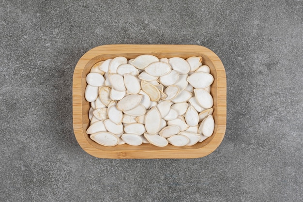 Graines de citrouille séchées sur plaque en bois.