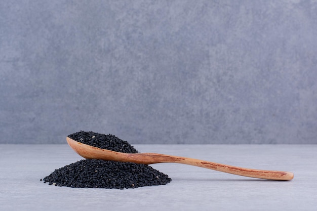 Graines de cumin noir dans une cuillère en bois. photo de haute qualité