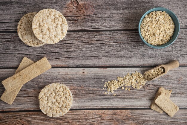 Les grains d'avoine dans un bol en plastique avec des craquelins sur la table