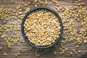 Grains de blé dans un bol et maïs soufflé dans un bol, semences de blé rustique