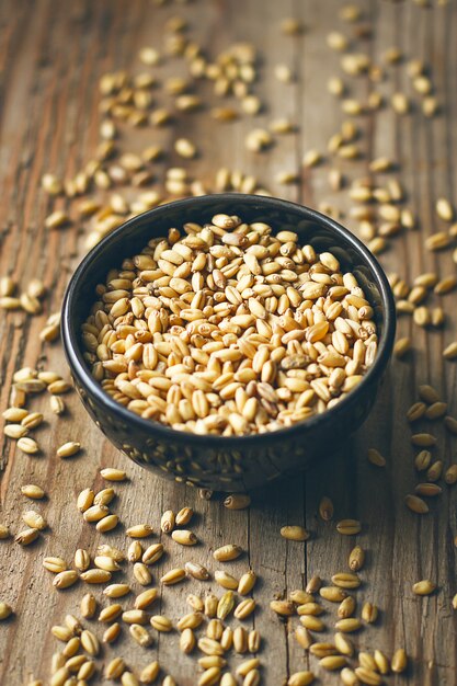 Grains de blé dans un bol et maïs soufflé dans un bol, semences de blé rustique