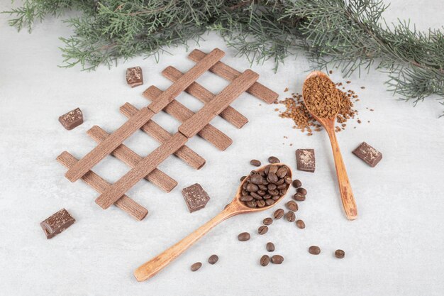 Grains de café, café moulu, biscuits et chocolat sur une surface en marbre