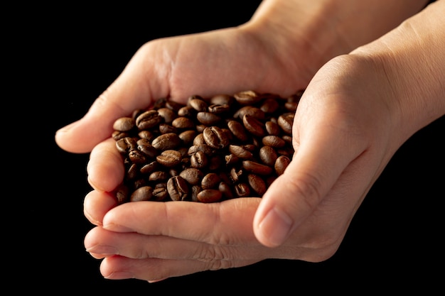 Grains de café dans les mains d'un homme