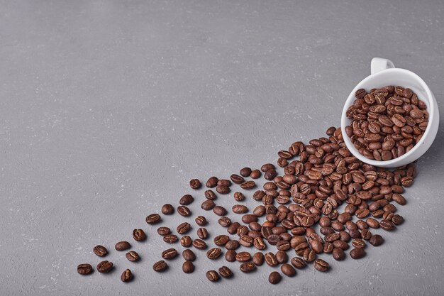 Grains de café dans une tasse blanche.