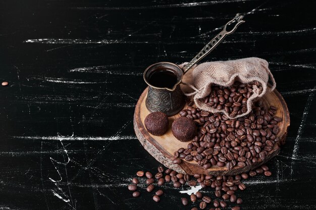 Grains de café sur fond noir avec des pralines.