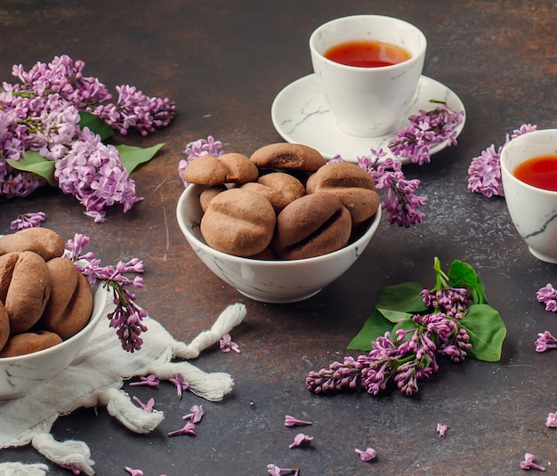 Les grains de café forment des biscuits avec des tasses blanches de thé.