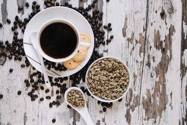 Grains de café non torréfiés près d&#39;une tasse de café