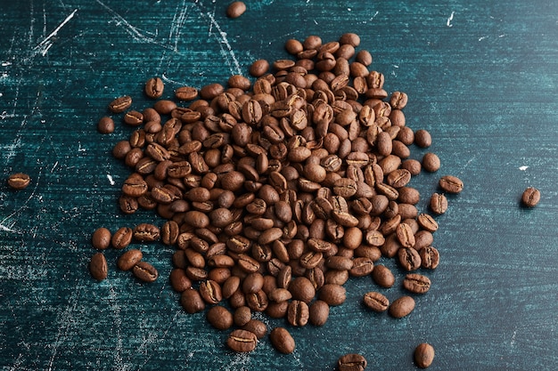 Grains de café sur une surface bleue.