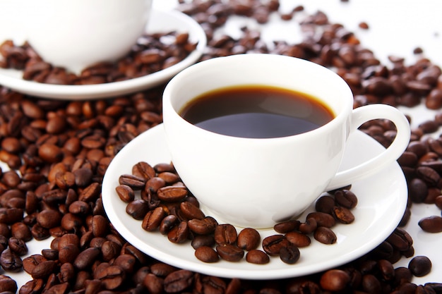 Grains de café avec des tasses blanches