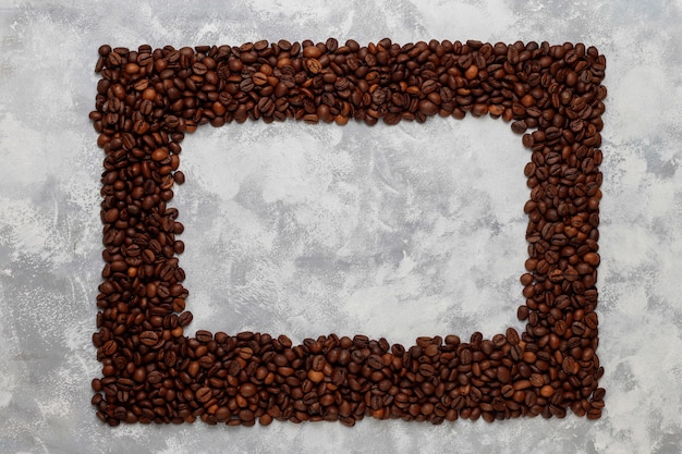 Grains de café torréfiés frais sur béton, vue de dessus, plat poser