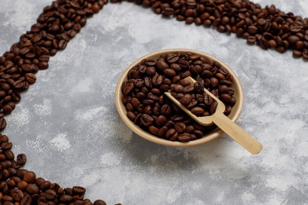 Grains de café torréfiés frais sur béton, vue de dessus, plat poser