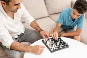 Photo gratuite grand angle adulte et enfant jouant aux échecs