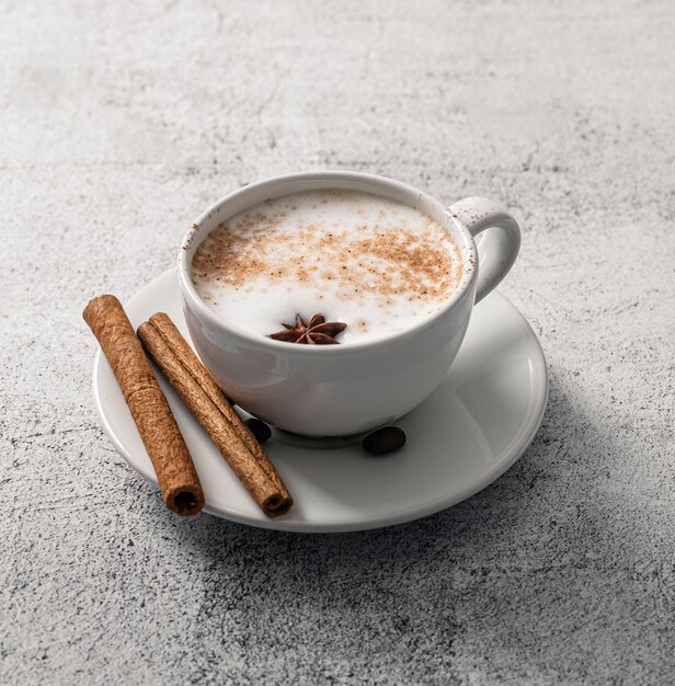 Photo gratuite grand angle de tasse de café avec des bâtons de cannelle et de l'anis étoilé