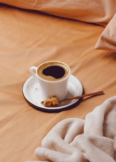 Grand angle de tasse de café du matin sur le lit