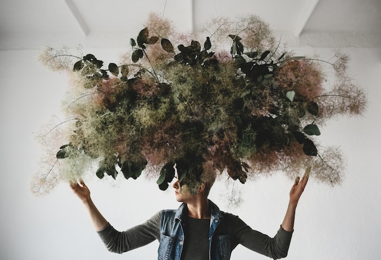 Photo gratuit grand bouquet décoratif fait de feuilles vertes et de mousse suspendu au-dessus de la tête de l&#39;homme