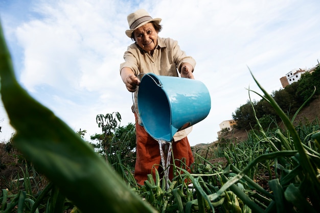 Grand-mère arrosant les plantes du jardin