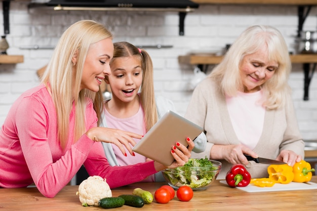 Grand-mère Cuisine Et Les Femmes Utilisent La Tablette
