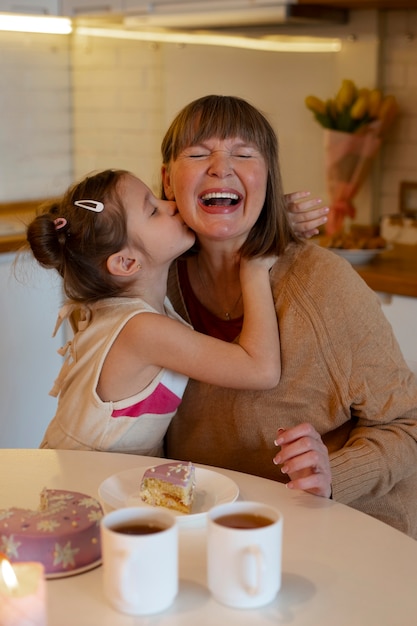 Photo gratuite grand-mère embrassée sur la joue par la famille