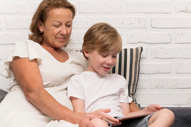 Photo gratuite grand-mère et enfant smiley avec tablette