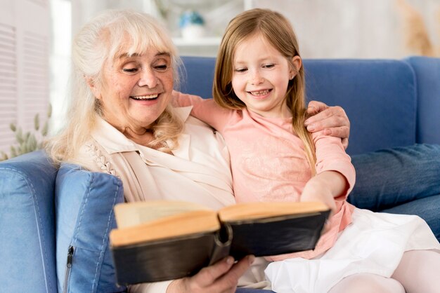 Grand-mère lisant pour fille à la maison